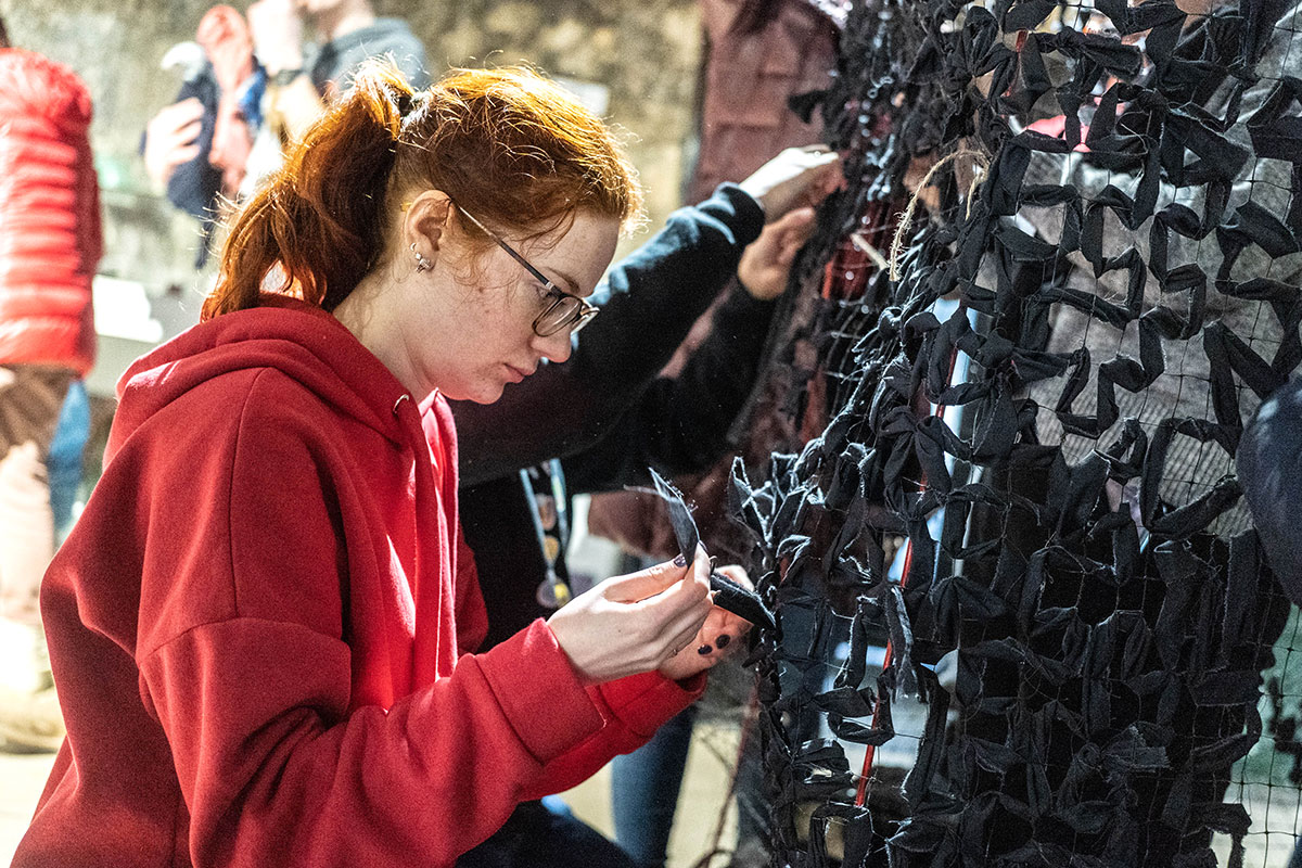 Young women weaves a scrim for the Armed Forces of Ukraine
